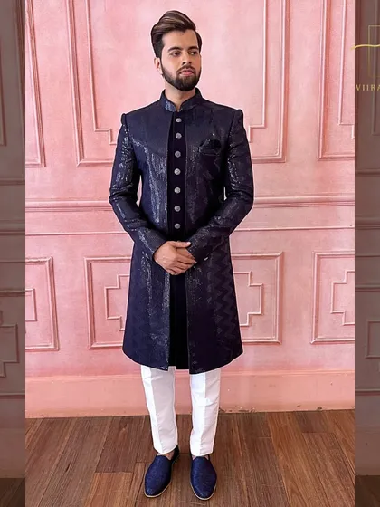 Our popular navy blue textured sherwani. The subtle pattern on the fabric adds depth, and it's paired with white trousers for a classic contrast.