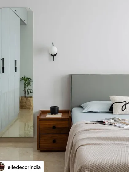 This serene bedroom detail from 'House Nandini' was highlighted in our Elle Decor feature. The minimalist aesthetic, with its clean lines, soft grey headboard, and simple wooden nightstand, creates a calming atmosphere.