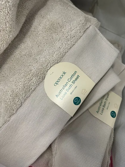 A stack of the beige Australian cotton bath sheets, showing the quality of the weave and the neat hem. These details are what I look for when sourcing items for you.