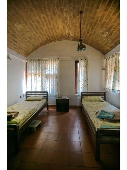 A simple and calm guest bedroom under a vaulted brick roof. This technique, along with thick earth walls, helps maintain a comfortable temperature inside the room throughout the year without any mechanical cooling.
