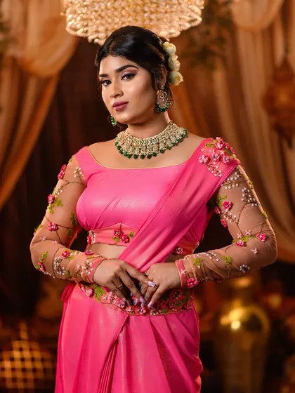 We masterfully recreate looks from every era of Bollywood. This elegant pose captures the timeless grace of Shantipriya, highlighting the custom-designed pink saree with floral embroidered sleeves and classic retro styling.