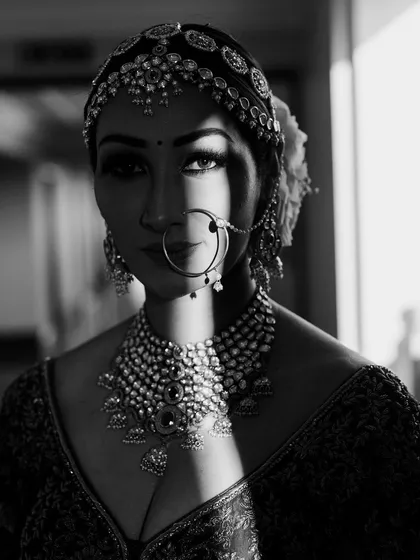 A powerful black and white bridal portrait, where the play of light and shadow creates a dramatic, high-contrast image that emphasizes the bride's striking features.