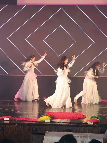 The ladies' batch performing a graceful routine to "Aaja Nachle" in elegant white outfits.