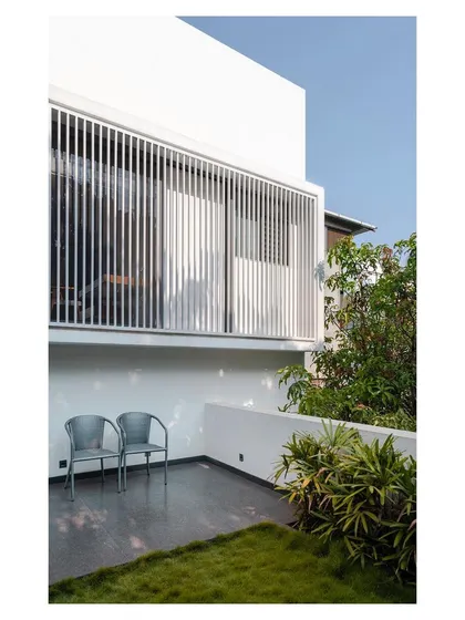 A private terrace in the "Solid | Void | Solid House" is screened for privacy with vertical fins. This creates a secluded outdoor space for relaxation.