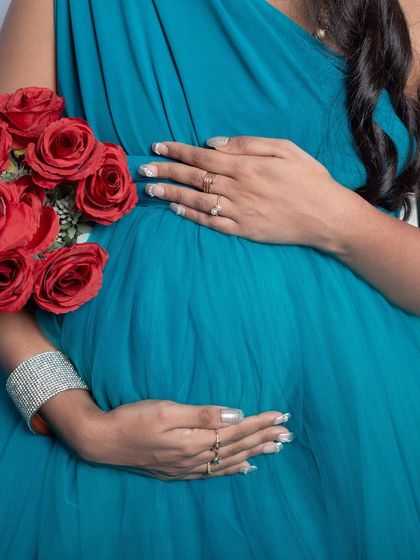 A close-up detail of a gorgeous teal maternity gown. I pay attention to the little things, like making sure your hands and the fabric look beautiful as you cradle your baby bump.