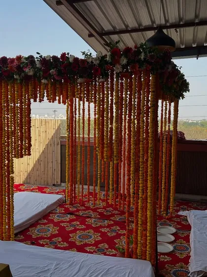 A wider angle of the outdoor marigold mandap, showing the seating arrangement for the ceremony.
