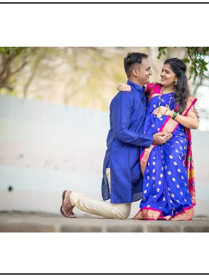 A classic pose for an expecting couple, with the partner kneeling to embrace the baby bump. This shot, done in traditional attire, is full of reverence and joy.