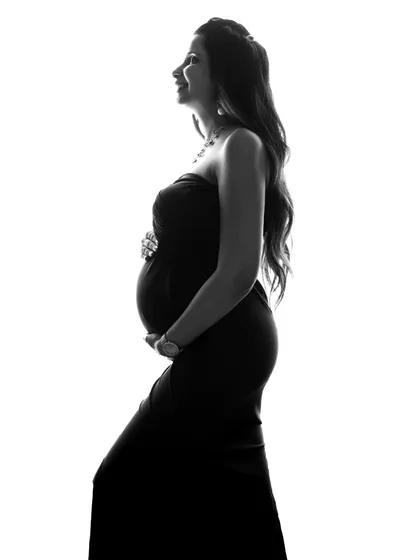A simple and elegant silhouette. This black and white profile shot beautifully highlights the mom-to-be's baby bump, creating a classic and artistic maternity portrait.