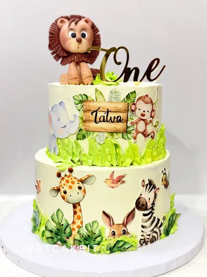 A two-tier jungle theme cake featuring a combination of a 3D edible lion and 2D printed animals. This mix of techniques creates a lovely storybook effect.