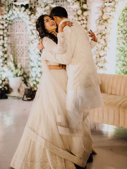 A joyful hug between the couple at their white-themed engagement party.