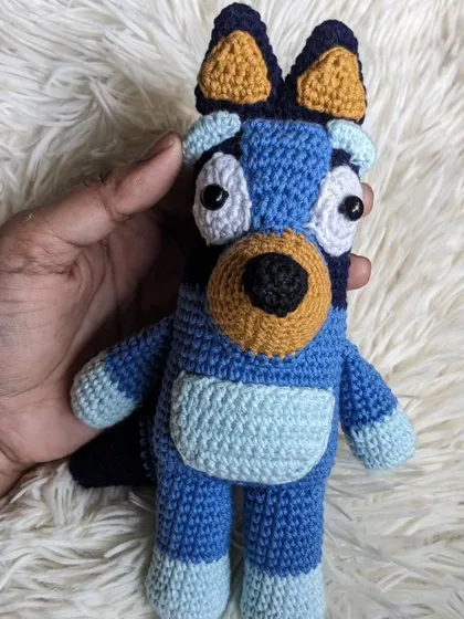 A handmade crochet doll of Bluey, the lovable character from the children's show.