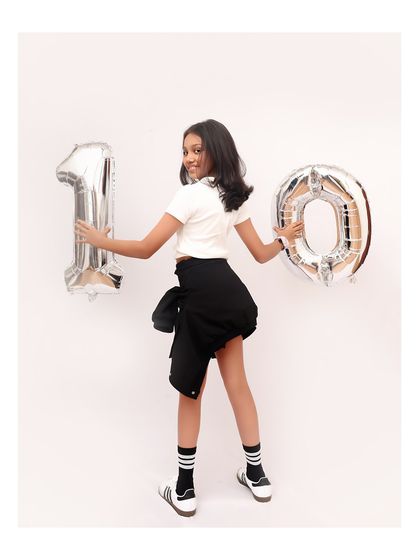 Turning ten in style. I also do milestone photoshoots for older kids, capturing their personality with fun props like these large number balloons.