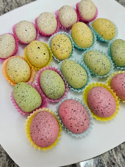 The pastel speckled eggs arranged in colorful cupcake liners.