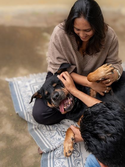 Playful chaos and pure joy. This candid shot captures the fun and energy of a family playing with their dog on the floor.