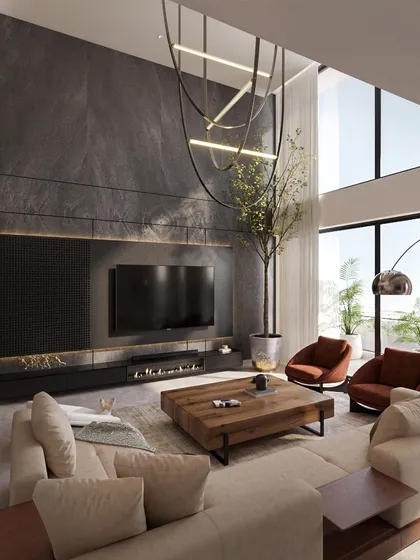 A different view of the double-height living room, showcasing the dramatic stone-clad TV wall, modern fireplace, and the custom chandelier that fills the vertical space.