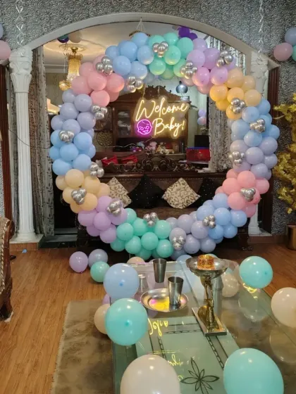 A beautiful pastel rainbow balloon ring to welcome a new baby. The soft colors and central neon sign create a dreamy and gentle atmosphere for the celebration.