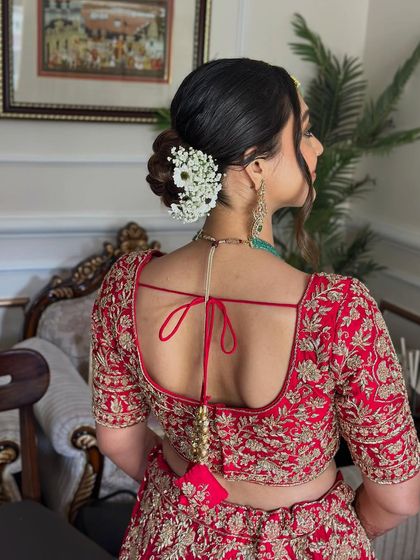 This soft, twisted bridal bun is adorned with a delicate arrangement of baby's breath, creating a look that is both romantic and sophisticated. It’s a versatile style that works beautifully for the ceremony or reception.