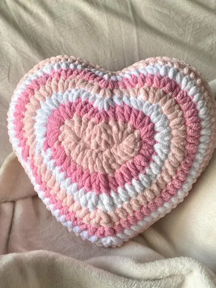 Add a pop of cozy cuteness to your room with our handmade crochet heart pillow. This plushie is made with super soft, chunky yarn in shades of pink and white, creating a trendy, y2k-inspired look that's perfect for your bed or couch.