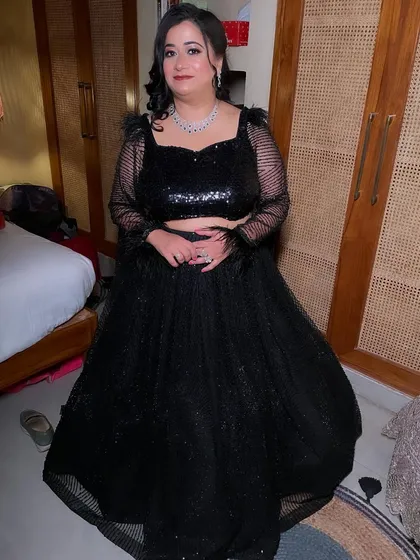 A chic cocktail look in a black sequined lehenga. The makeup is glamorous with a smokey eye, perfect for an evening event.