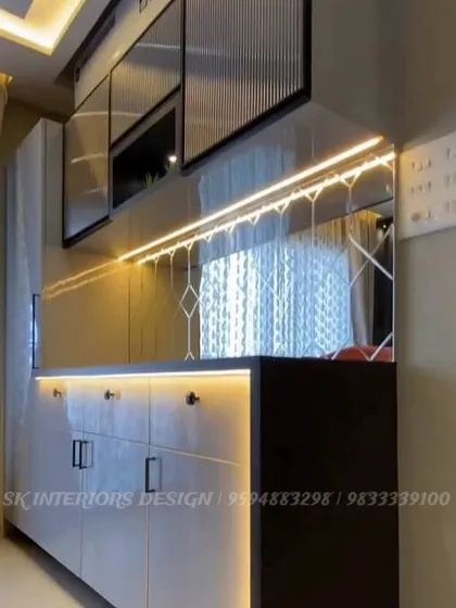 A close-up of a custom buffet counter with under-cabinet lighting. The mirrored backsplash with a geometric pattern adds a touch of glamour and reflects light beautifully.