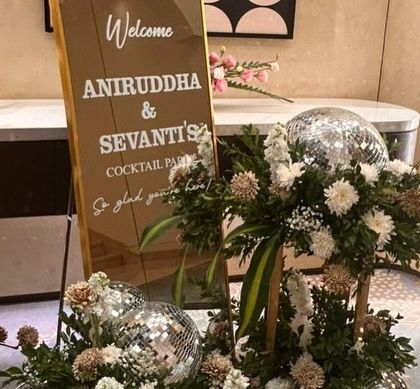 A personalized welcome sign for a cocktail party. We used a mirrored sign for a modern look and added disco balls and floral arrangements to hint at the fun, celebratory night ahead.