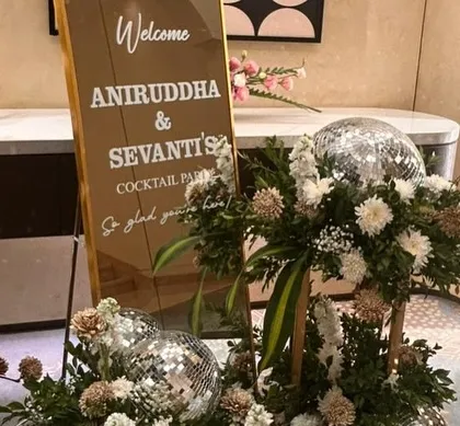 A personalized welcome sign for a cocktail party. We used a mirrored sign for a modern look and added disco balls and floral arrangements to hint at the fun, celebratory night ahead.