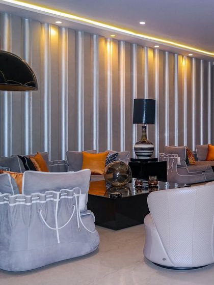 A living space that blends classic charm with vibrant accents. The unique sofas with corset like detailing and pops of orange create a space that is handcrafted, curated, and uniquely enchanting.