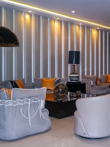 A living space that blends classic charm with vibrant accents. The unique sofas with corset like detailing and pops of orange create a space that is handcrafted, curated, and uniquely enchanting.