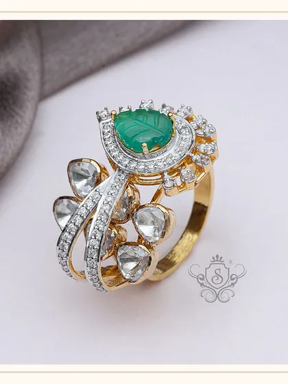 This unique ring combines a carved green gemstone with a spray of uncut diamonds (polki) and brilliant-cut diamonds. The mix of textures and diamond styles creates a piece that is both traditional and contemporary.