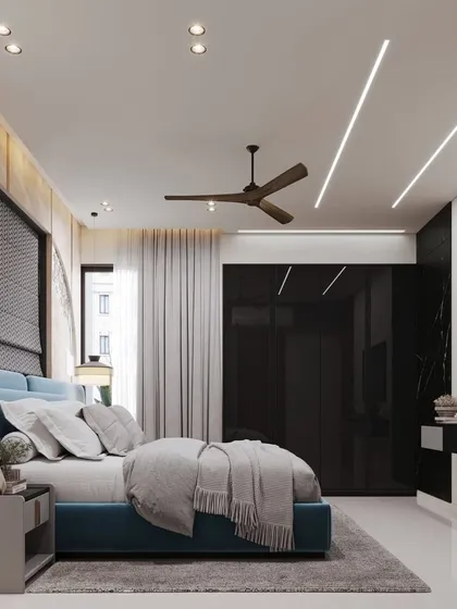 A view of a modern bedroom featuring a blue bed and a full-wall wardrobe with black glass doors. The combination of colors and materials creates a bold and contemporary aesthetic.