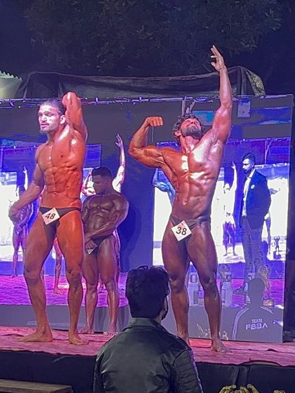 Hitting a classic pose at the Mr. Asia competition. Stage presence is just as important as muscle, and I make sure my athletes command attention.