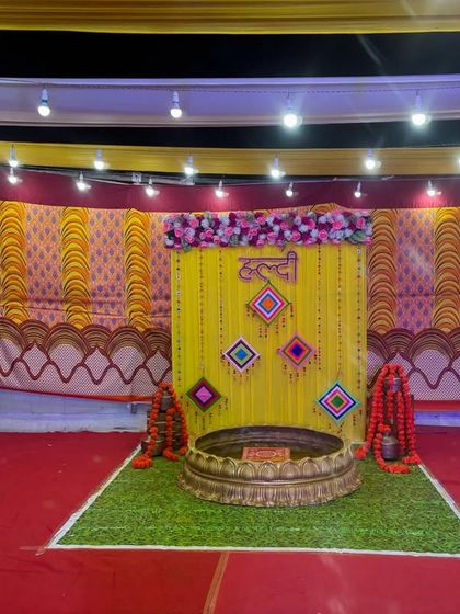 The full pandal setup for a Haldi ceremony. We use a combination of printed and plain fabrics to create a festive environment, with the main stage as the focal point.