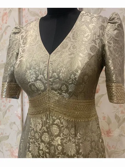 The V-neck and puffed sleeves of the Banarasi brocade jumpsuit give it a chic and structured look, perfect for a modern festive event.