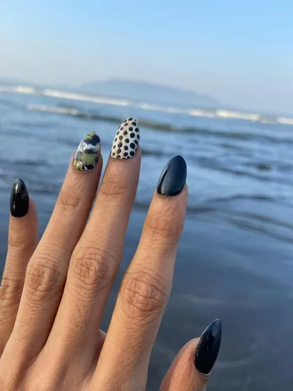 Party nails ready for the beach. This look features a mix of solid black, dalmatian print, and a unique camo-glitter design for a bold and edgy style.