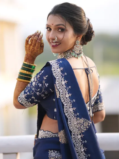 A modern take on the Maharashtrian bride. The stunning navy blue Nauvari saree is complemented by a soft glam makeup look, a chic bun, and elegant silver-toned jewellery.