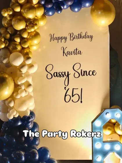 A close-up of the "Sassy Since '65" birthday backdrop, showing the elegant font and the sophisticated color scheme of the balloon decor.
