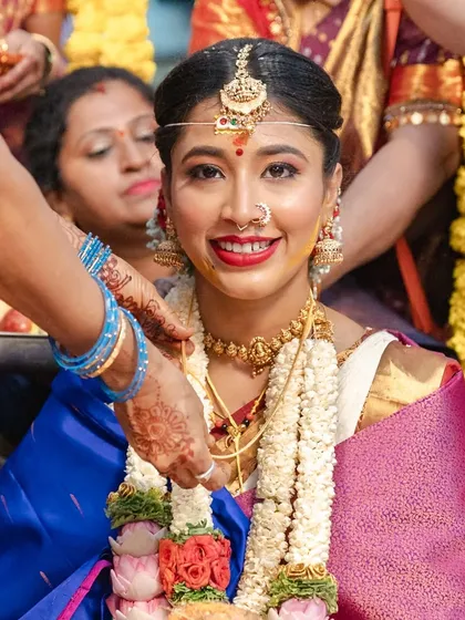 I believe a bride's true radiance shines through in the quiet moments. Here, amidst the beautiful chaos of a traditional Kannada wedding, her joyful smile says everything.