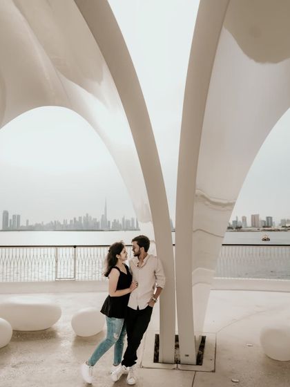 A wide shot showing the couple against the modern architecture and waterfront of Dubai.