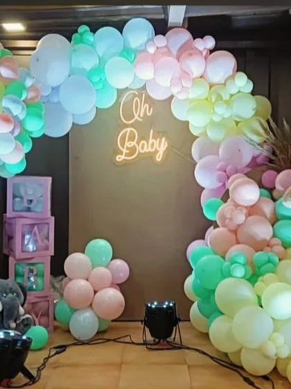 A creative take on a baby shower theme, this setup features a hot air balloon concept. We used a wicker basket with a teddy bear and a vibrant pastel balloon arch, all highlighted by a warm "Oh Baby" neon sign.