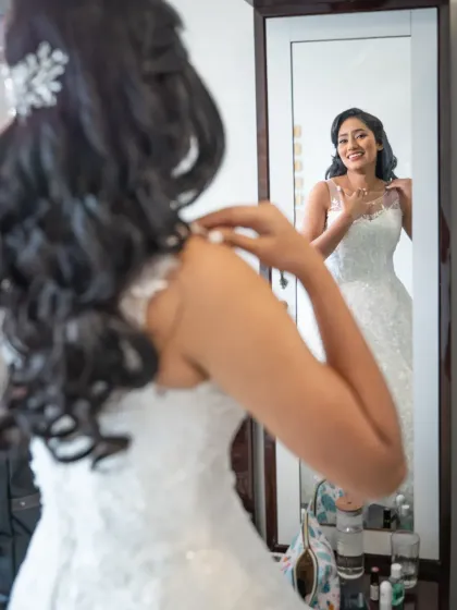A happy, candid moment of the bride getting ready. The reflection in the mirror adds a lovely compositional element to this joyful shot.
