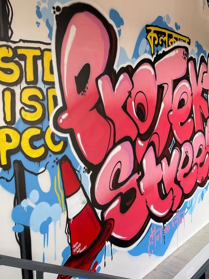 A wider shot of the "Projekt Street" mural, showcasing the full composition. The piece incorporates classic street art elements, including my tag on a directional sign, integrating the brand into an authentic graffiti style.