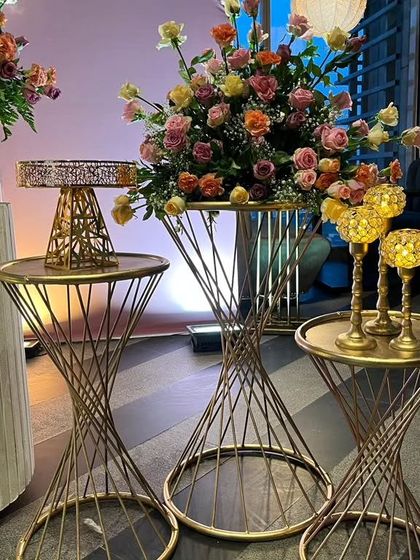 A close up of the elegant decor elements, showing the intricate design of the golden spiral tables and the beautiful floral centerpiece.
