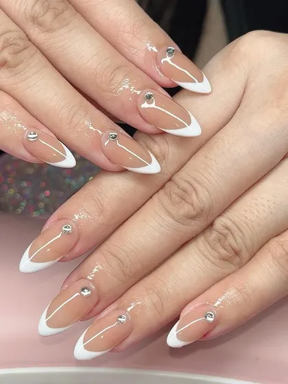 A refined and elegant design. I created these stiletto French tip nails and added a single, perfectly placed rhinestone on each nail for a minimalist glam look.