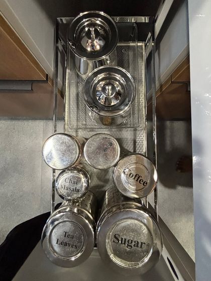 A pull-out drawer dedicated to tea, coffee, sugar, and chai masala. Creating a designated beverage station like this simplifies the process of making your morning chai or coffee.
