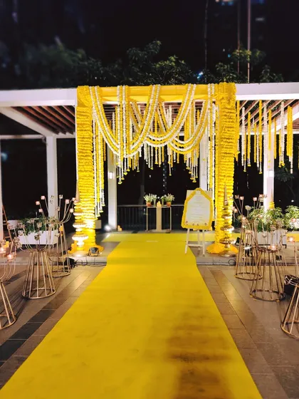 The destination of the grand yellow pathway: a beautiful floral archway made of marigolds, creating a perfect welcome point for the Sai Sandhya event.
