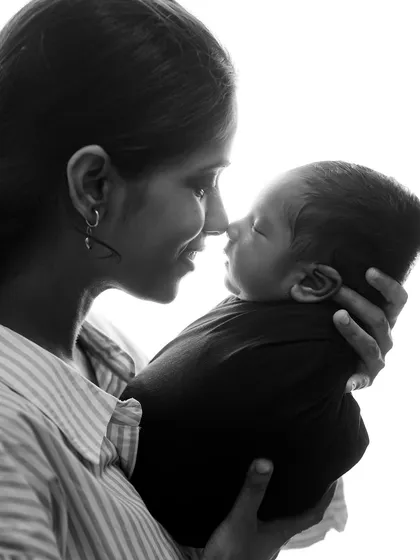 The quiet, tender connection between a mother and her newborn. This black and white portrait uses soft, natural light to highlight the emotion of the moment, creating a timeless and classic family photograph you will cherish forever.