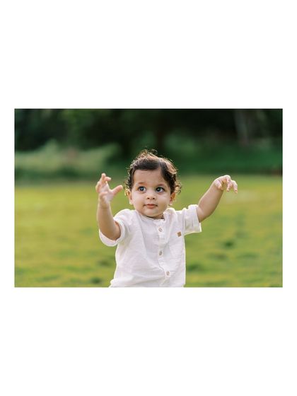 A baby boy reaching out, full of curiosity. We were lucky to get this shot after a rain delay.