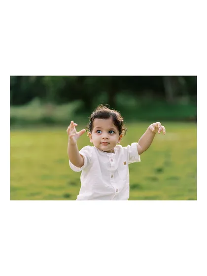 A wide shot of the baby boy reaching for the sky, showing the beautiful, open space we used for his outdoor session.
