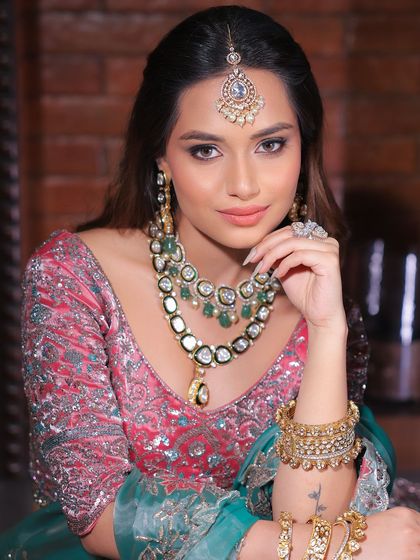 A close-up that captures the essence of modern bridal beauty. The focus is on flawless skin, defined brows, and a soft lip, allowing the statement jewellery to shine.