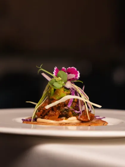 A close-up of our signature Uttapam Taco, filled with savory mushroom and broccoli and topped with fresh garnishes. It's a perfect one-bite wonder that encapsulates our food philosophy.